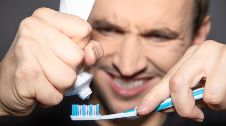 Man squeezing toothbrush