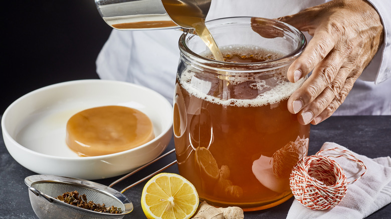 man making home brewed kombucha