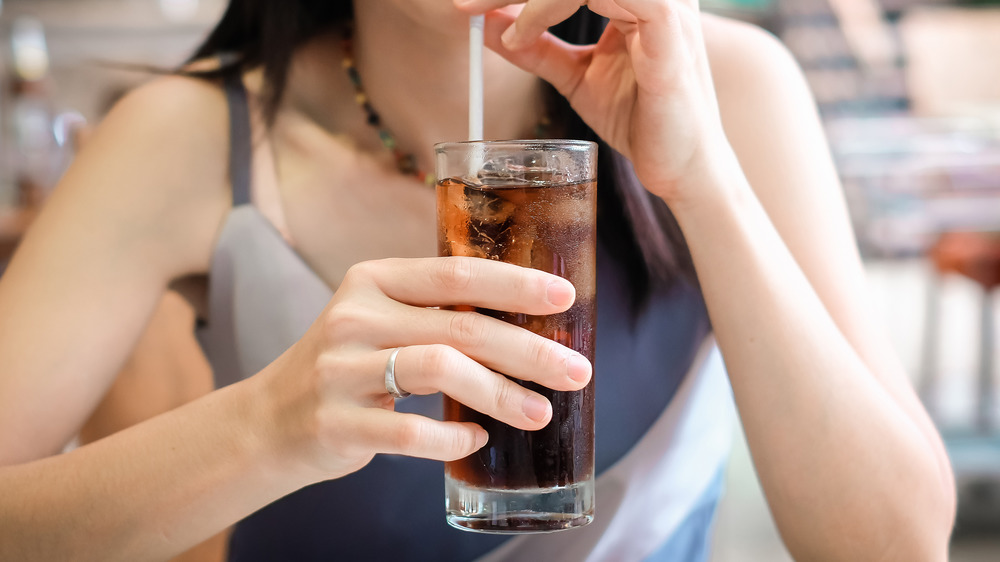 Woman drinking soda through straw