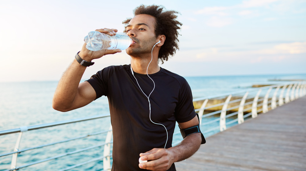 Man drinking water bottle on run