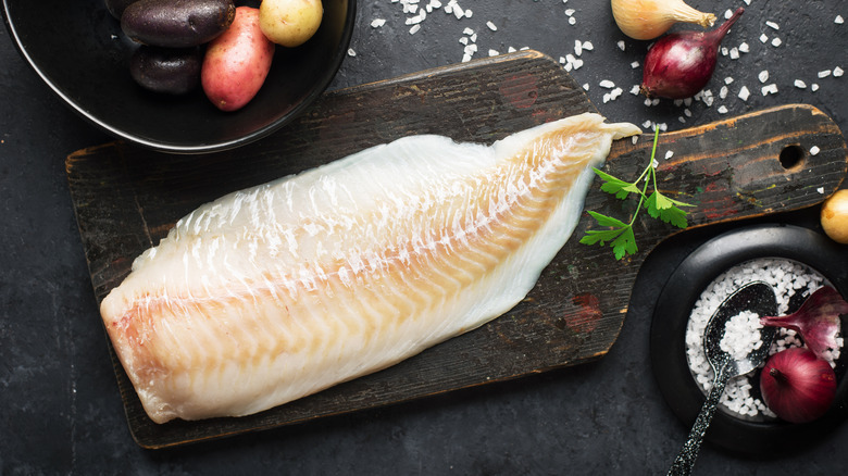 A cod fillet on a cutting board