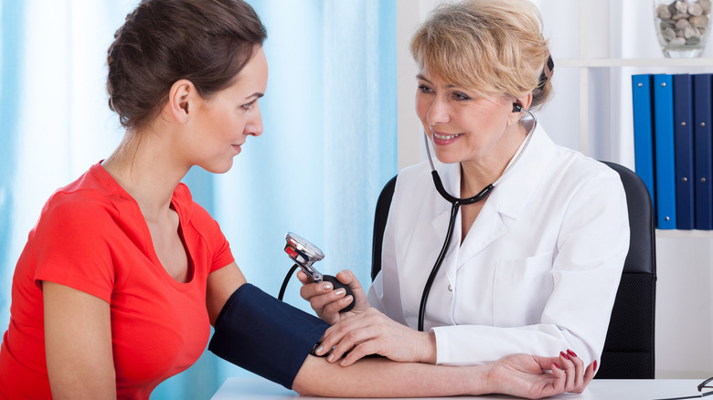 doctor measuring woman's blood pressure
