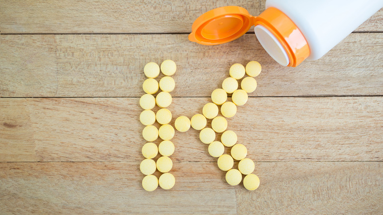 Potassium supplement forming letter K on wood background