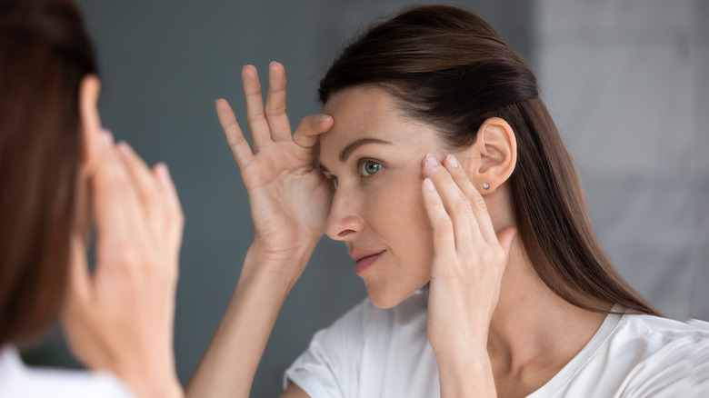 woman inspecting face