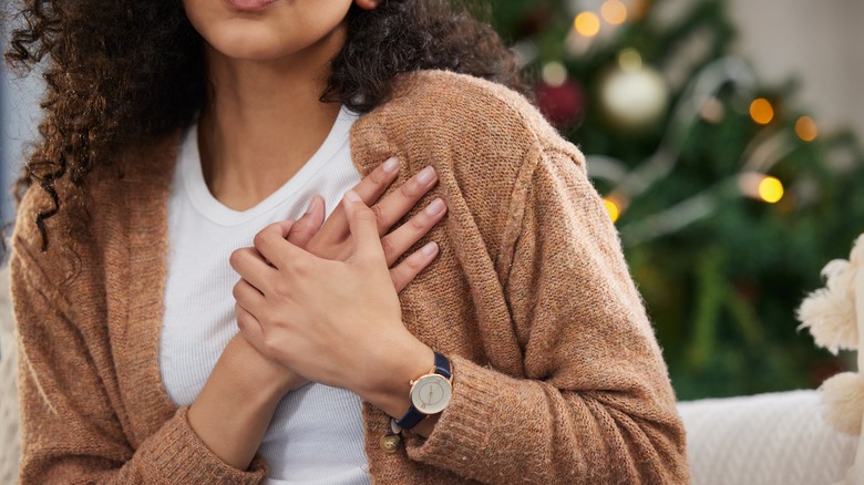 Woman holding chest in pain