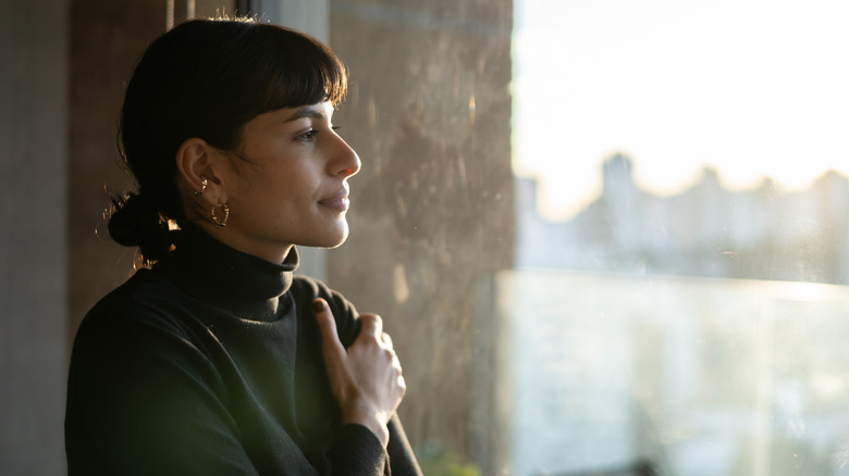 Woman daydreaming staring outside window