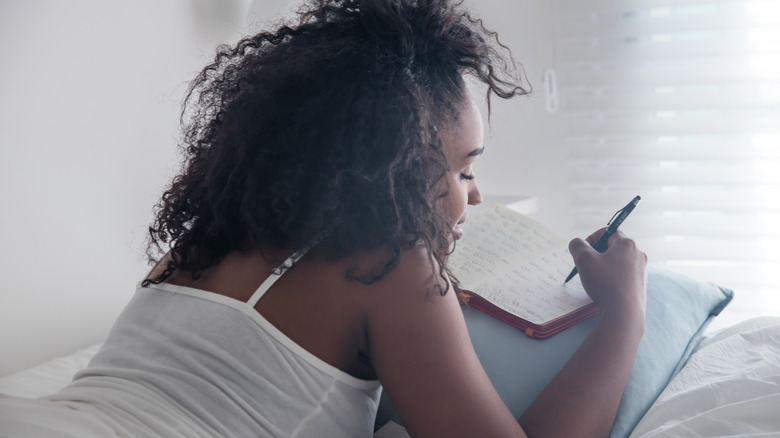 Woman journaling in bed