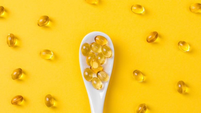 vitamin E-filled capsules on spoon