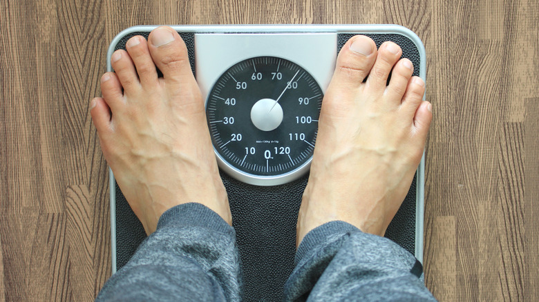 Man on scale gaining weight