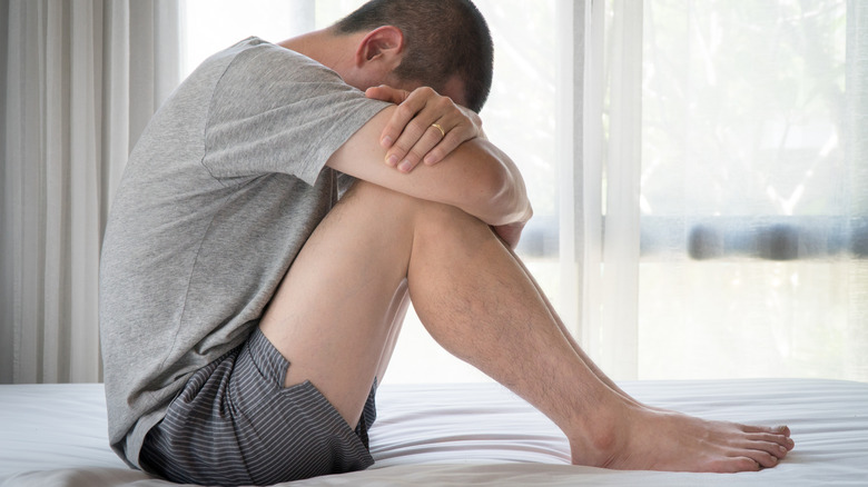 Depressed man on bed