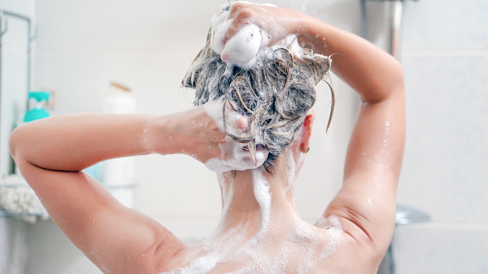 person washing hair while showering