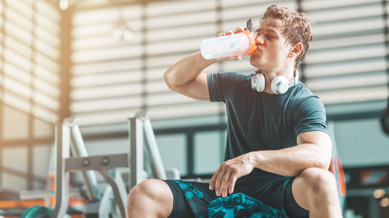 A man takes a pre-workout supplement before exercise