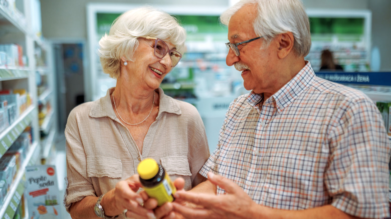 older couple choosing a vitamin or supplement in store