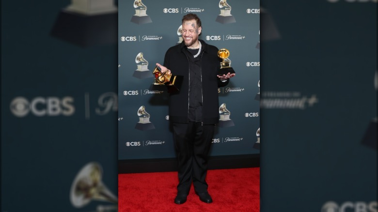 Jelly Roll at the Grammys holding his awards and smiling